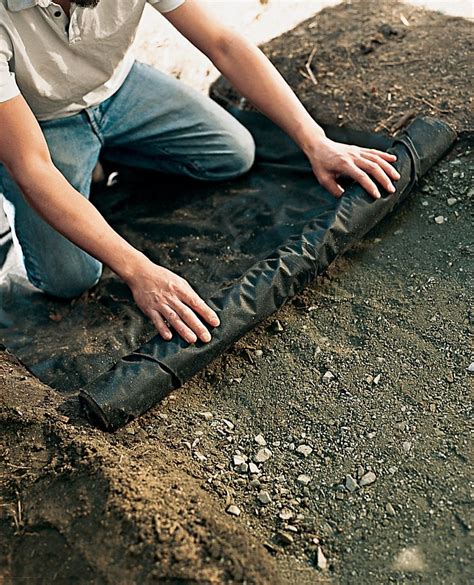 Lay landscape fabric over compacted stone base before installing the edging, keeping it taut ...