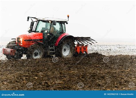 Tractor plowing a field stock photo. Image of scene - 142296318