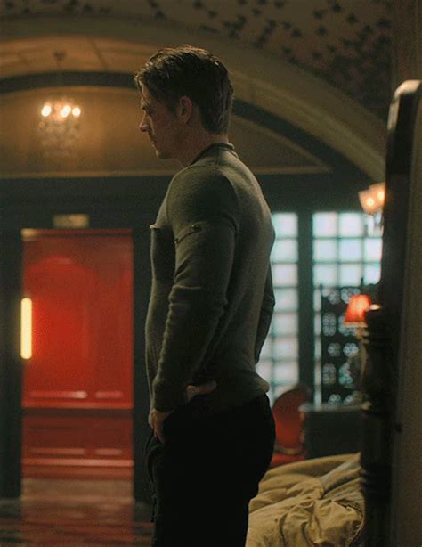 a man standing in front of a red door with his back turned to the camera