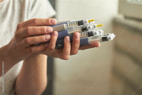 Diabetes insulin dependent concept, hands with syringes pen injectors with doses of humalog for ...