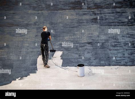 Construction site, application of a bituminous coating on a concrete ceiling, preparation for ...