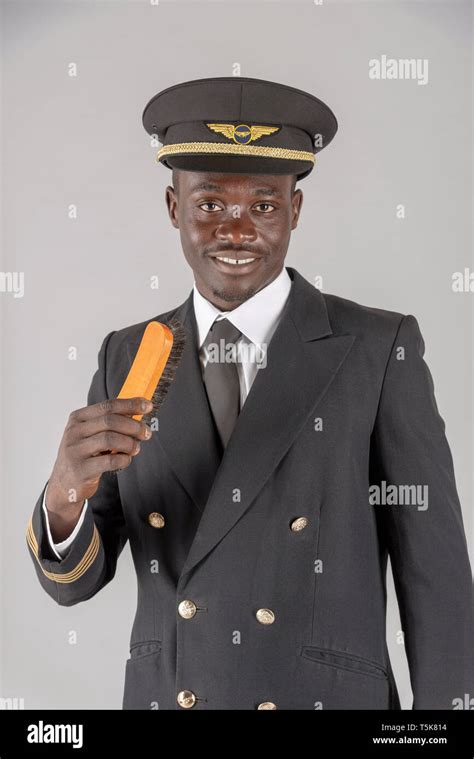 2019. An airline pilot brushing his captain's uniform Stock Photo - Alamy