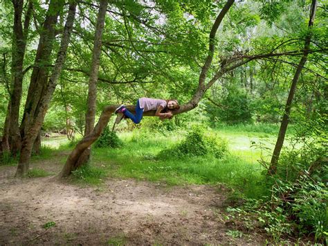 Smiling girl lying on a branch in the forest, Poland - Stock Photo ...