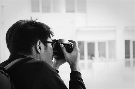 Depth of Field Photography of Man Holding Dslr Camera · Free Stock Photo