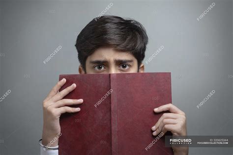 Portrait of a young boy holding a book in hand. — 10 15 years, people - Stock Photo | #320625344