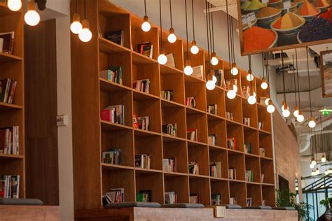 Books Inside Bookshelf Near Lit Pendant Lights · Free Stock Photo