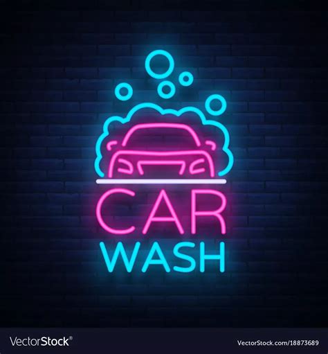 car wash neon sign in the dark with brick wall and blue light behind it,