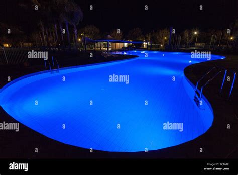 Luxury swimming pool glowing in blue light at night Stock Photo - Alamy