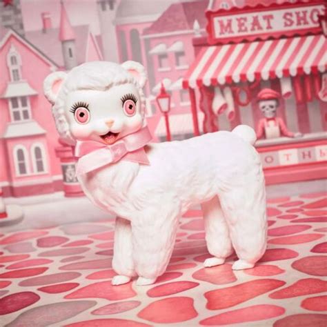 a white dog with pink eyes standing in front of a toy store and candy shop