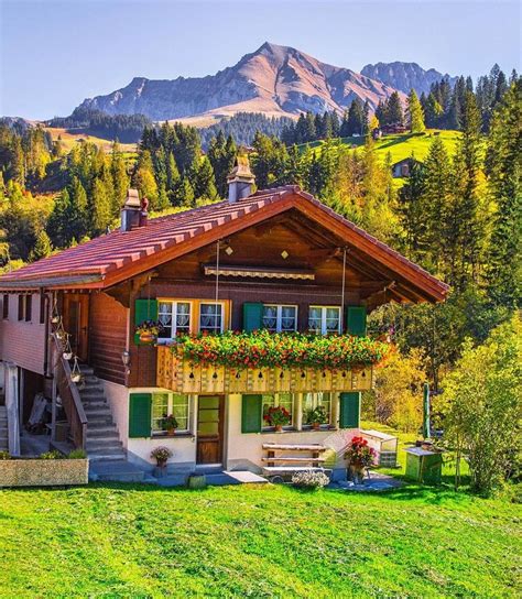 a house with green shutters and mountains in the background