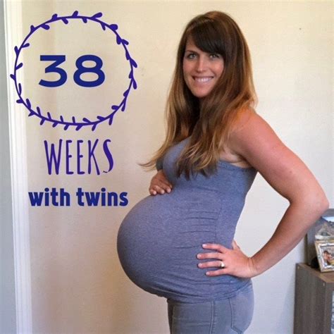 a pregnant woman standing in front of a sign