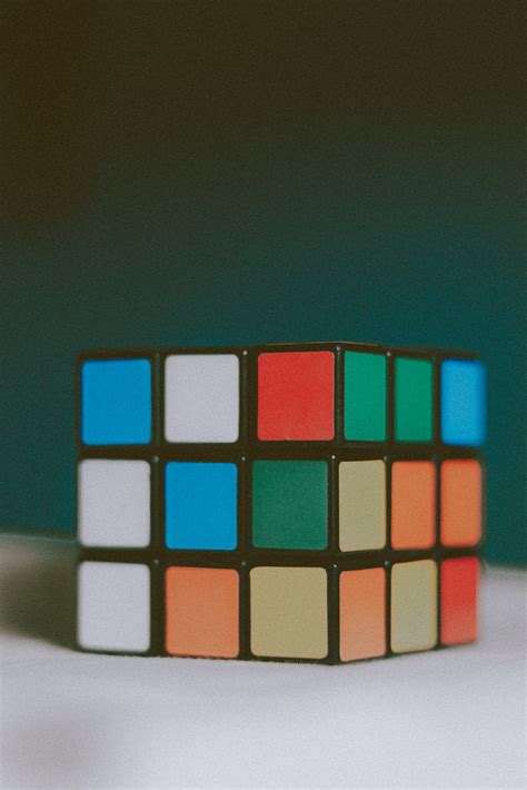 Colorful puzzle cube placed on white surface · Free Stock Photo