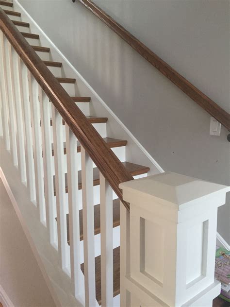 a white stair case with wooden handrails