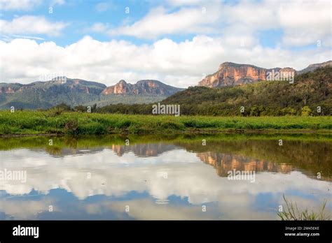 Steep cliffs of the Capertee canyon reflecting in water from the valley ...