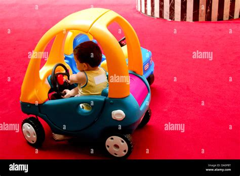 small kid driving toy car inside a play house at a shopping mall Stock ...