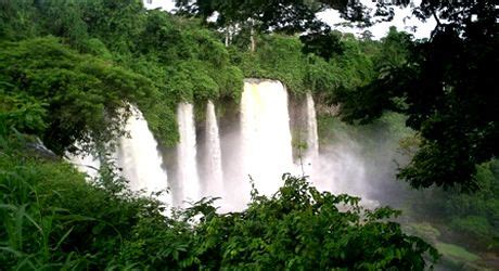 a large waterfall surrounded by lush green trees