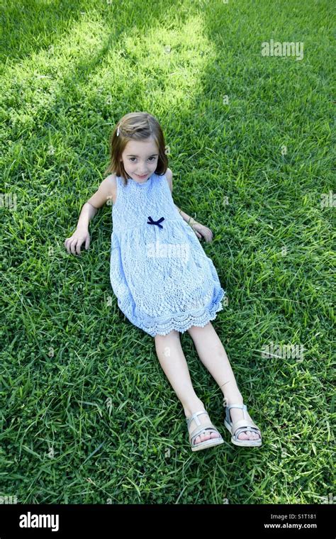 Little girl is lying to the grass Stock Photo - Alamy