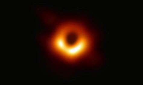 a black hole is seen in the dark sky, with an orange ring around it