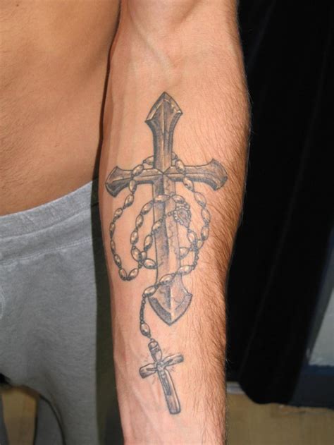 Religious gray-ink cross with beads tattoo on forearm - Tattooimages.biz