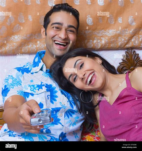 Young couple reclining on the bed and watching television Stock Photo - Alamy
