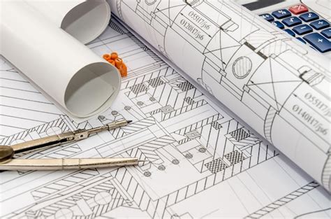 Premium Photo | Engineers drawing with compass, calculator and rolls