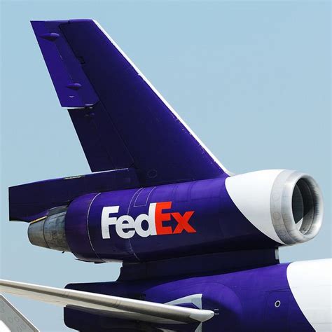 the tail end of an airplane that is painted blue and white with the fed ex logo on it