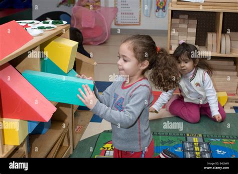 Kindergarten Mädchen ihr Spielzeug wegräumen Stockfotografie - Alamy