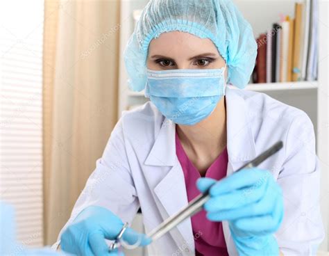 Beautiful female surgeon in mask hold needle, forceps and tweeze ...