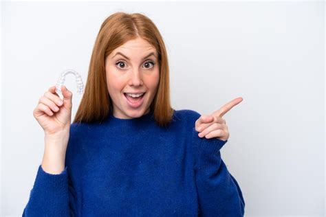 Premium Photo | Young redhead woman holding invisible braces isolated on white background ...