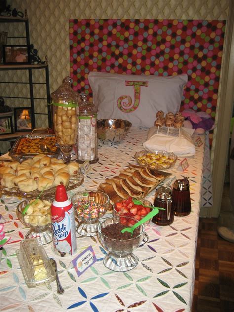 a table filled with food and drinks on top of a white cloth covered tablecloth