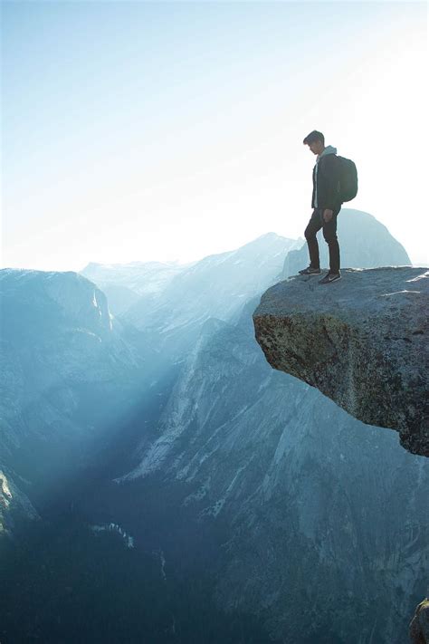 HD wallpaper: man standing on cliff, person standing on the top edge of mountain cliff ...