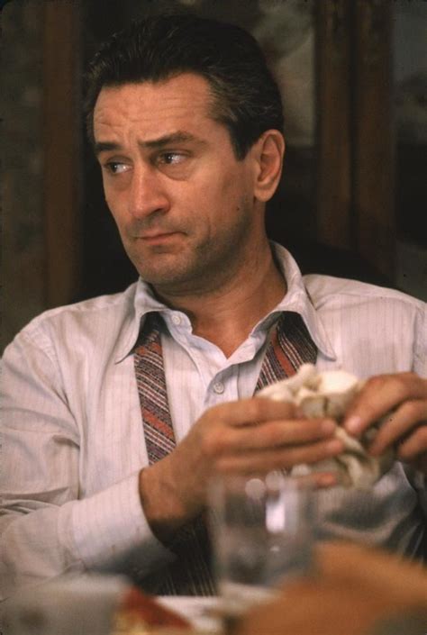 a man in a white shirt and tie eating food