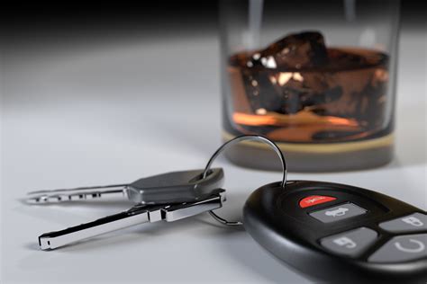 Whiskey glass and car keys on white studio background free image download
