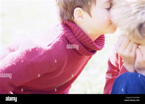 Child kissing second child on cheek Stock Photo - Alamy