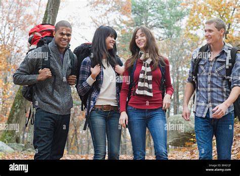 Young people hiking through forest Stock Photo - Alamy