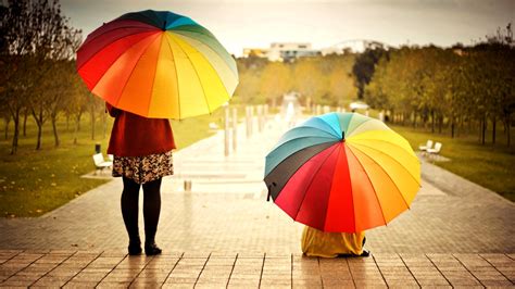 Two women with colorful umbrellas in the rain Wallpaper Download 3840x2160