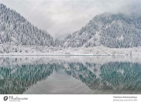 Mountain lake in winter. Snow-covered mountains are reflected in the ...