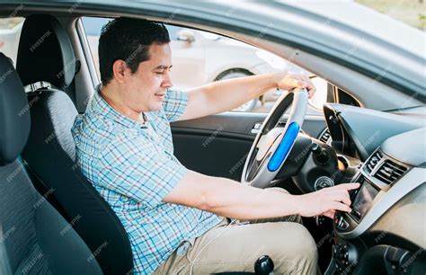 Premium Photo | Driver man changing the radio station Smiling driver ...