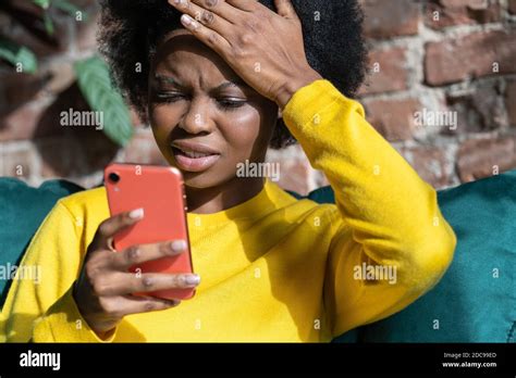 Mujer milenaria afro-americana confundida haciendo gesto facepalm, tocando la cabeza con la ...