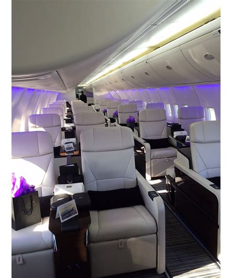 the inside of an airplane with white leather seats and purple lighting ...