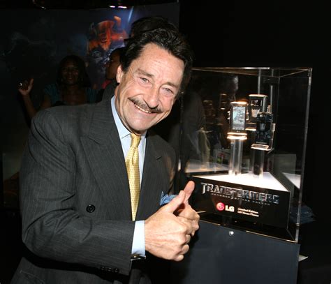 a man giving the thumbs up sign in front of a glass display case with an electronic device on it