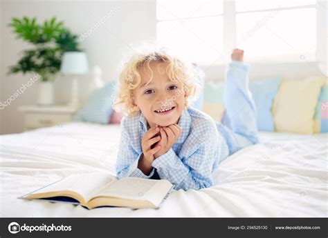 Child reading book in bed. Kids read in bedroom. Stock Photo by ...