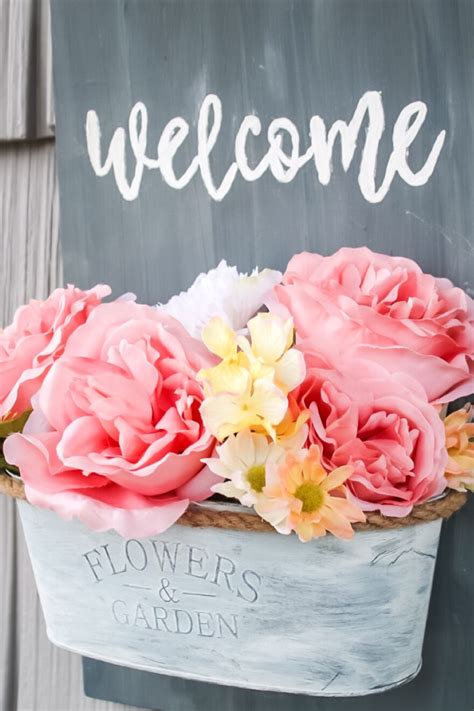 a welcome sign with pink and yellow flowers