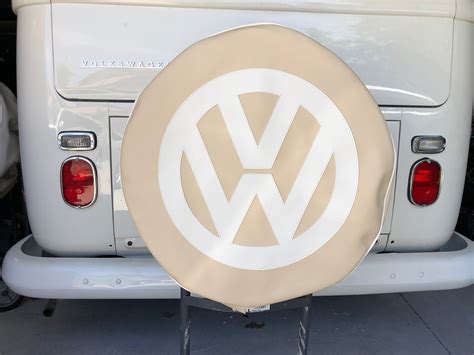 Spare wheel cover in light beige with white logo. – Resto Bus Parts