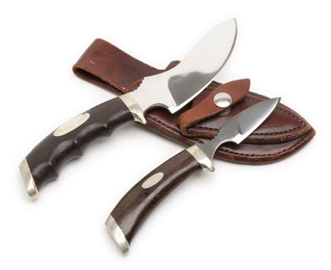 Set of 2 skinning knives in leather combo sheath marked “Track Knives/Whit