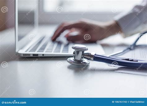 Doctor Working with Laptop Computer in Medical Workspace Office. Focus on Stethoscope Stock ...