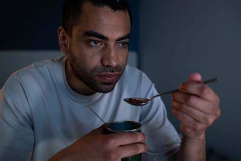 Man Holding a Spoon Eating Canned Food · Free Stock Photo