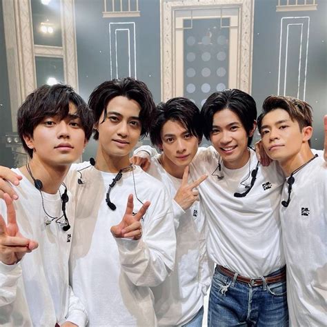 four young men posing for a photo in front of a mirror with one ...