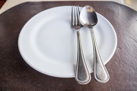 Top view of a white plate with a spoon and a fork 1740554 Stock Photo ...