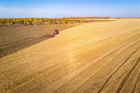 Premium Photo | Aerial view drone of harvest field with tractor mows dry grass. autumn yellow ...